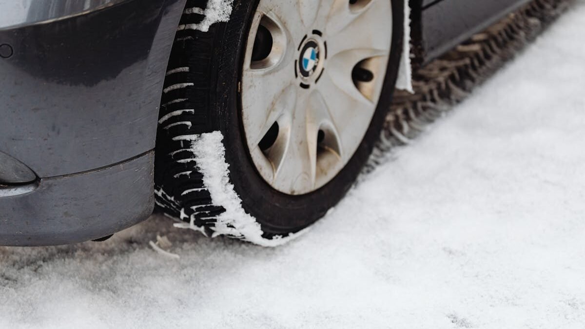 Iš arti nufotografuota automobilio padanga snieguotame kelyje