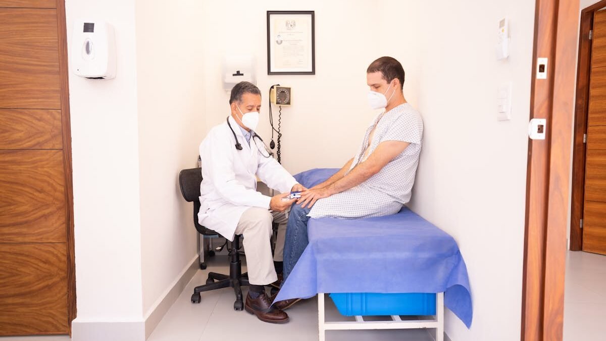 Gydytojas tikrina paciento gyvybinius požymius klinikoje konsultacijos metu