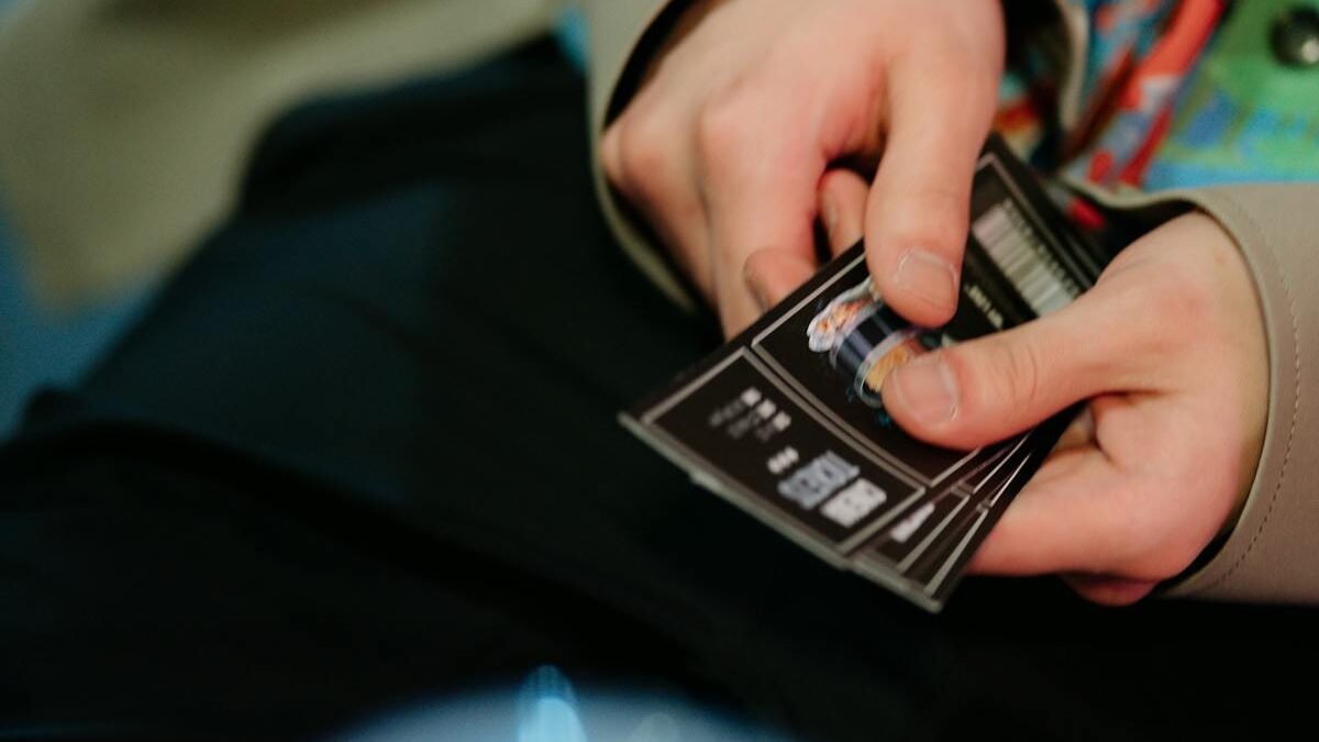 Iš arti nufotografuotos rankos su kino bilietais