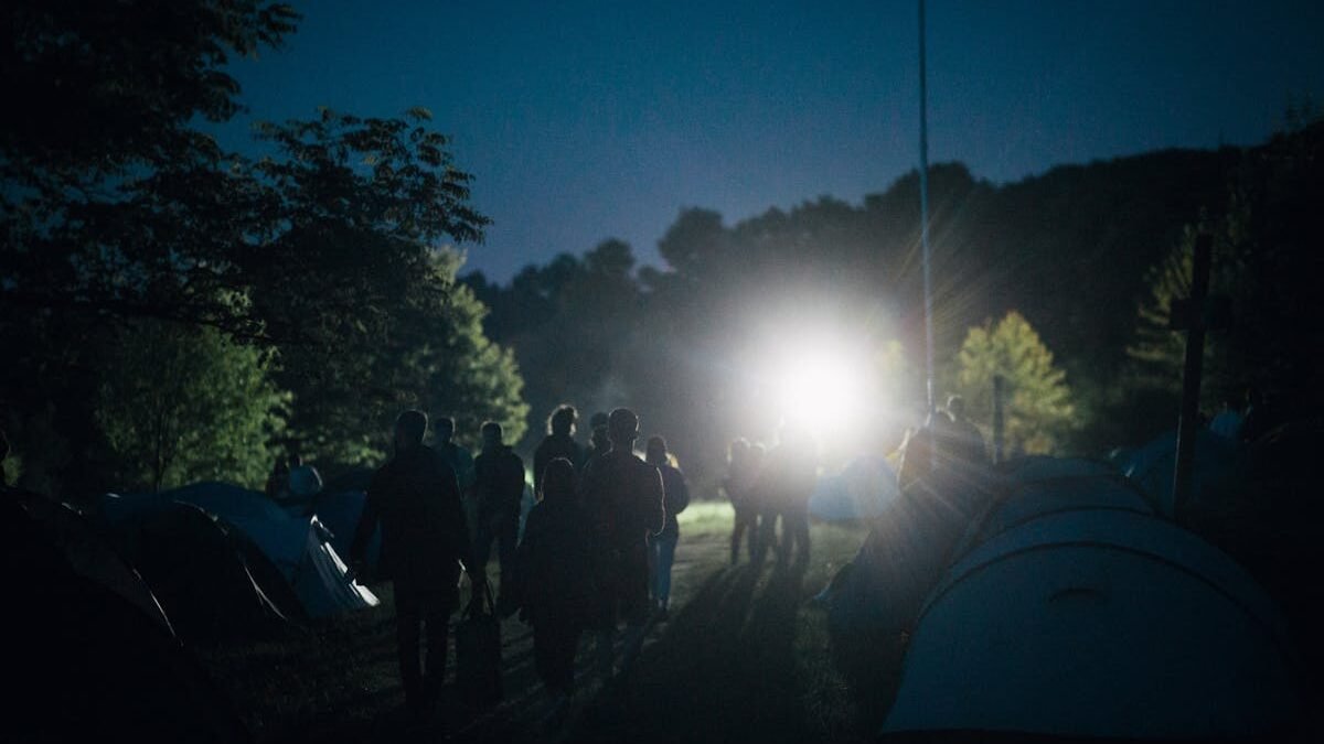 Grupė žmonių besimėgaujančių ramia nakvynę kempinge