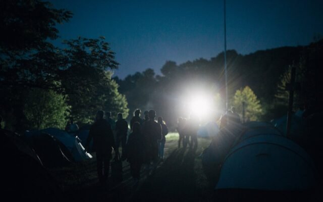 Grupė žmonių besimėgaujančių ramia nakvynę kempinge
