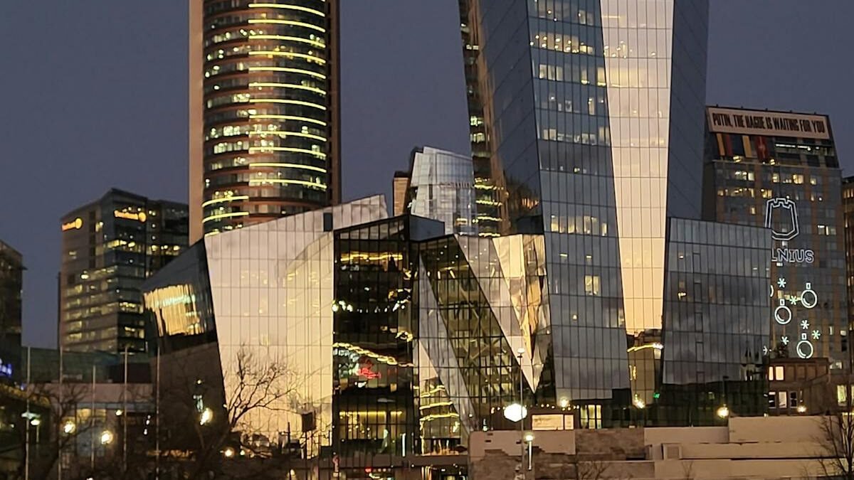 Užburianti Vilniaus dangoraižių nuotrauka sutemose su vaikščiojančiais žmonėmis